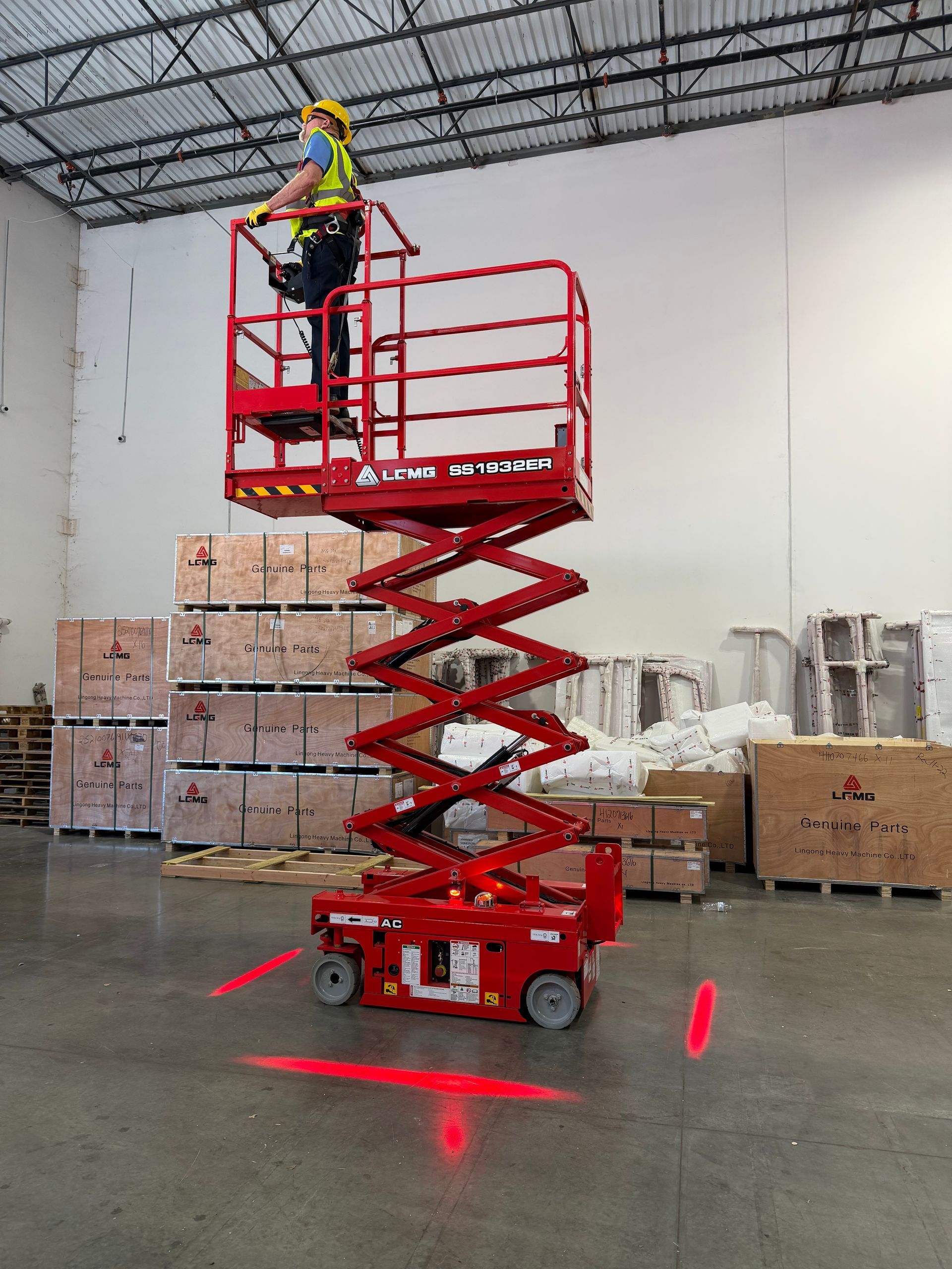 Construction equipment display booth with red machinery, LCMG sign, and people.