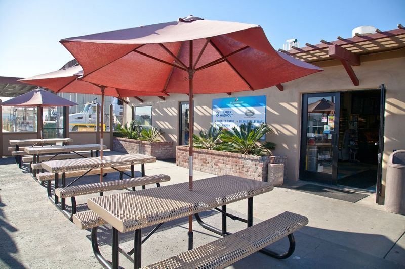 A picnic area with tables and umbrellas in front of a building