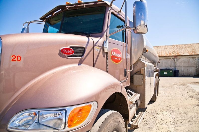 A brown truck with the number 20 on the front is parked in a gravel lot.