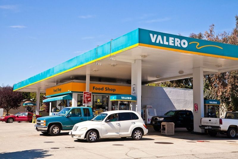 Cars are parked in front of a Valero gas station