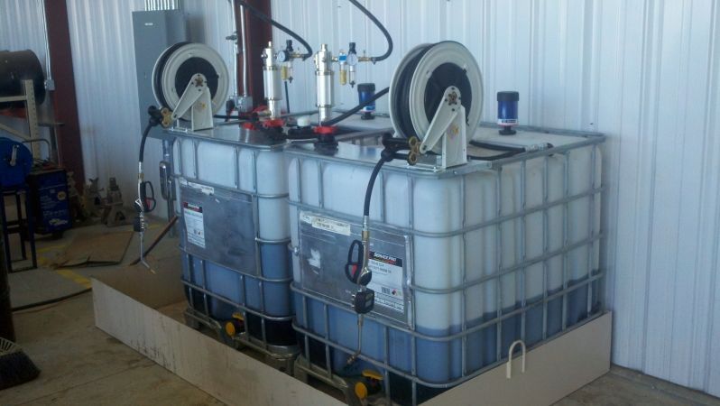 Two large containers filled with liquid are sitting on top of each other in a room.