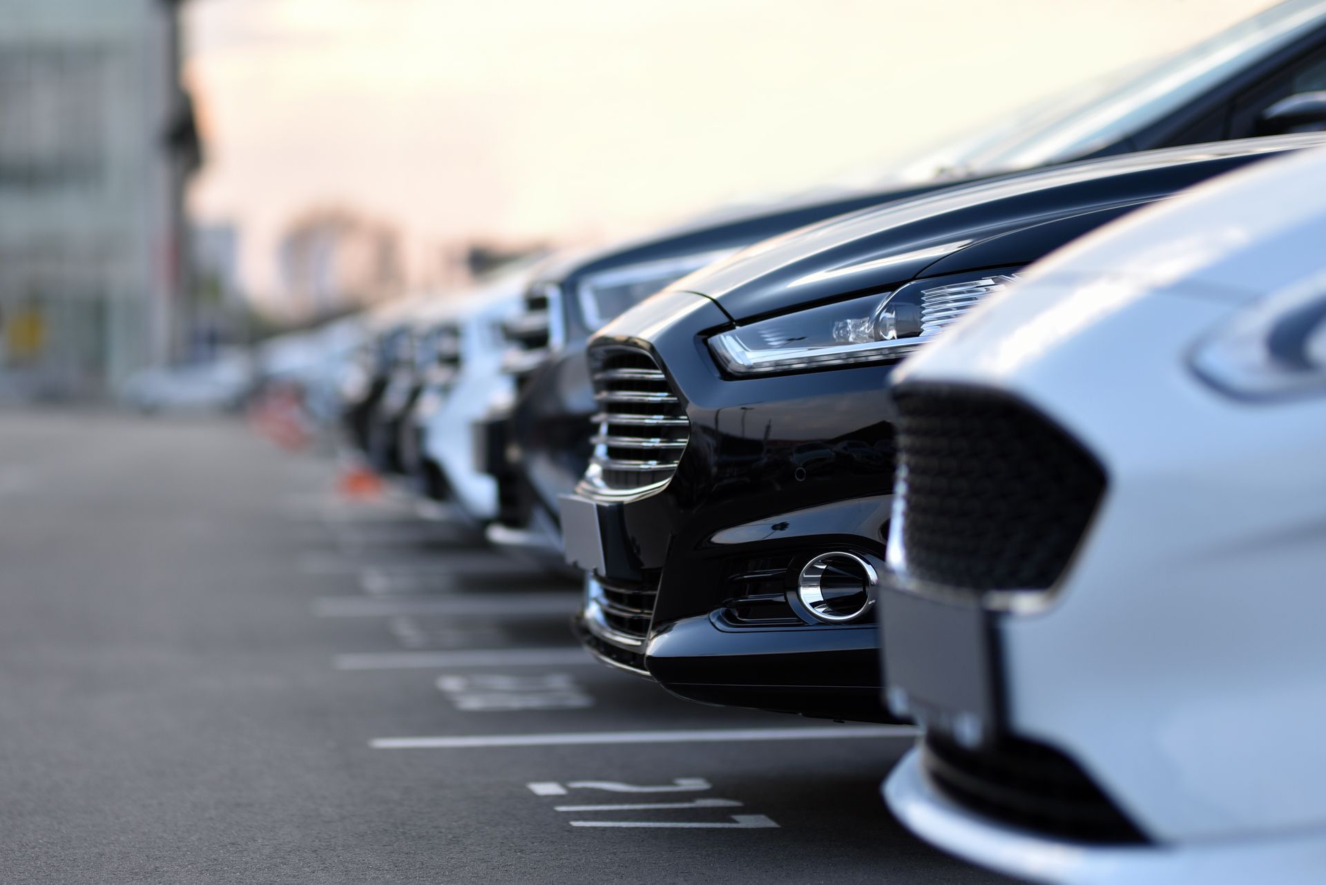 A row of cars are parked in a parking lot.