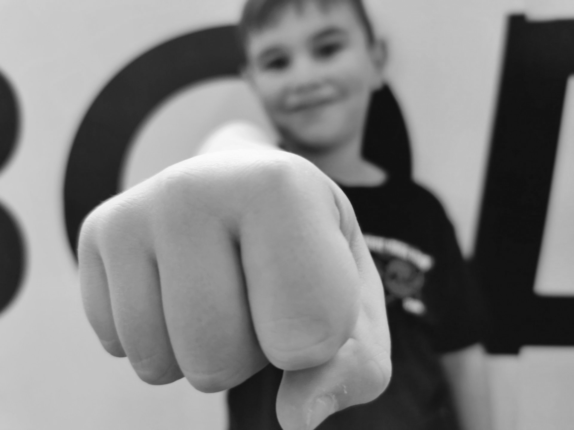 Kid's Classes - black and white Image of a young male punching towards camera with his right arm