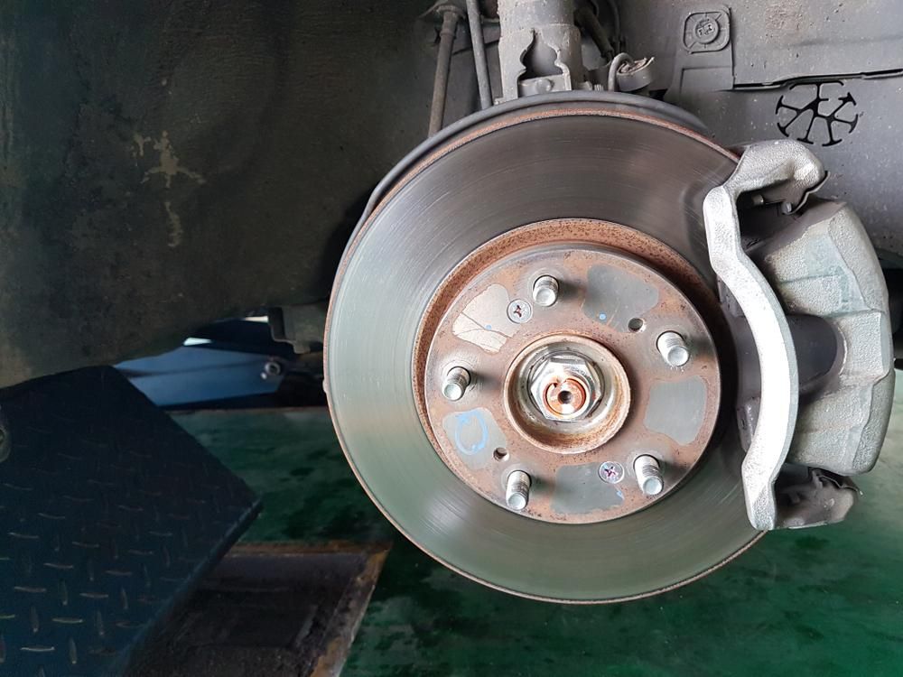 A Close Up Of A Brake Disc On A Car — Practic Automotive Services In Corrimal, NSW