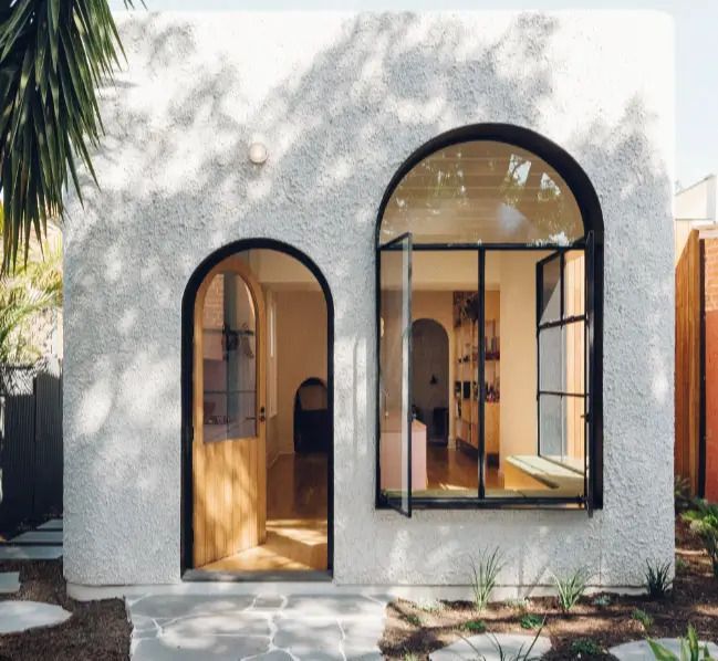 A white house with arched windows and doors.