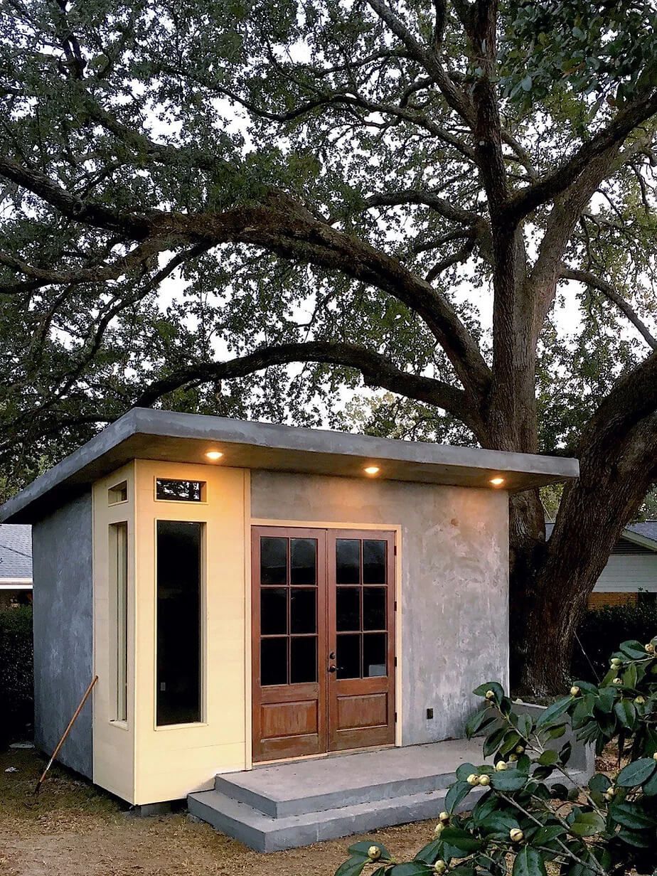 A small house with a large tree in the background.
