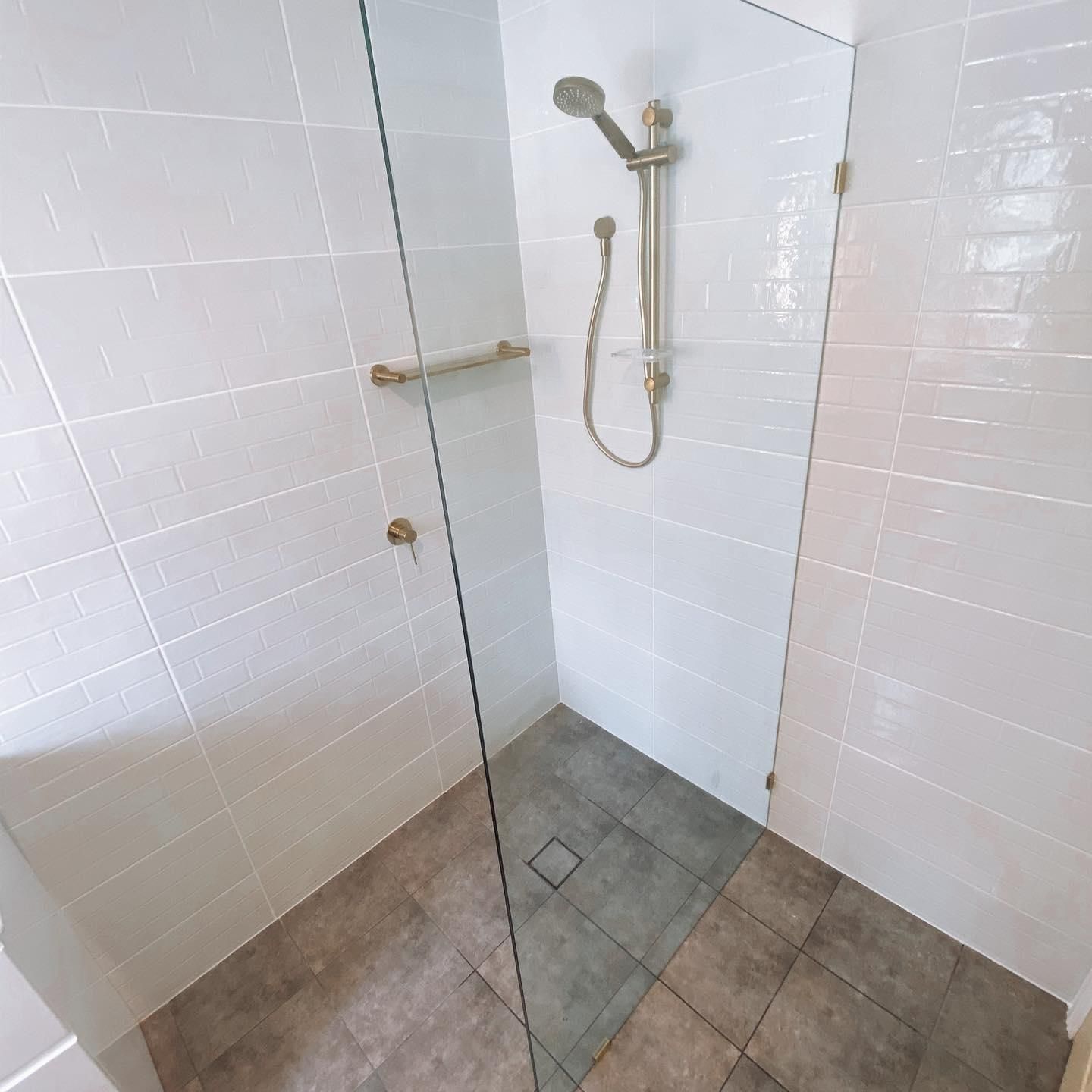 A Walk in Shower with A Glass Door and A Shower Head — Distinctive Glass In Nambucca Heads, NSW