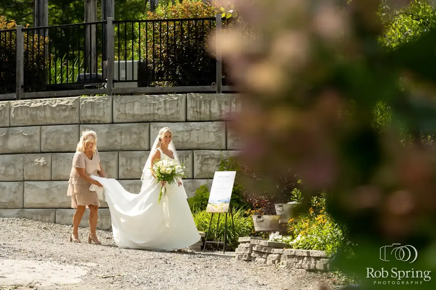 A bride and her mother are walking towards the ceremony area at a wedding.