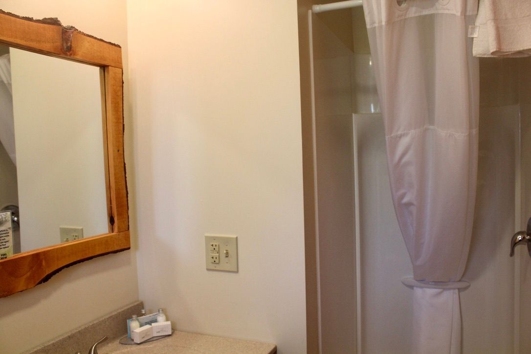 A bathroom with a sink a mirror and a shower curtain
