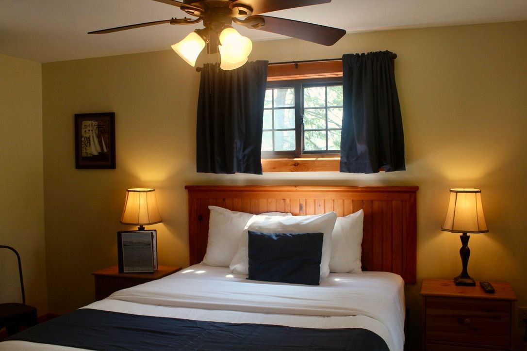 A bedroom with a bed and a ceiling fan