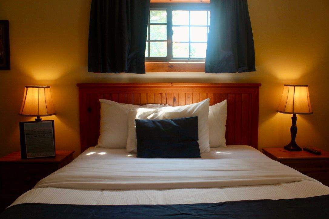 A hotel room with a bed and two lamps