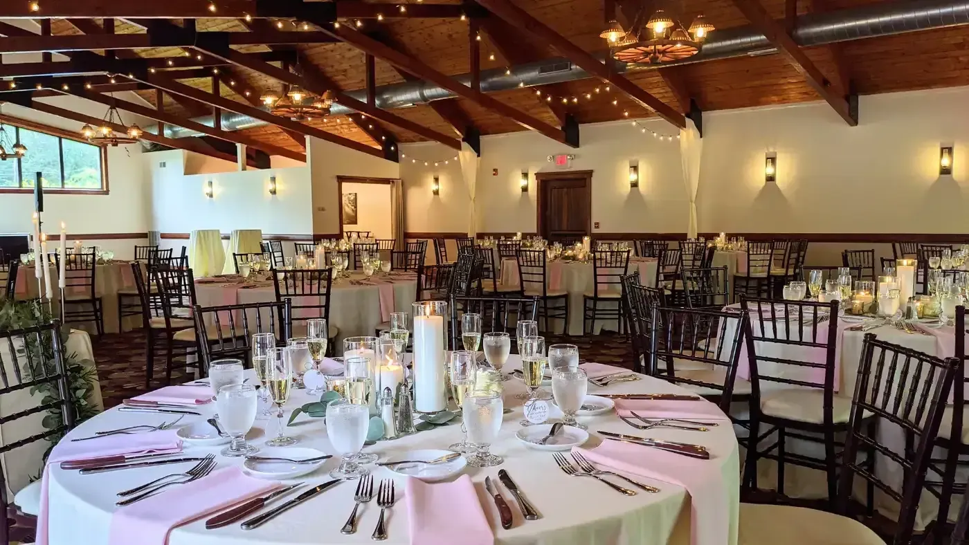 A large room with tables and chairs set up for a wedding reception.