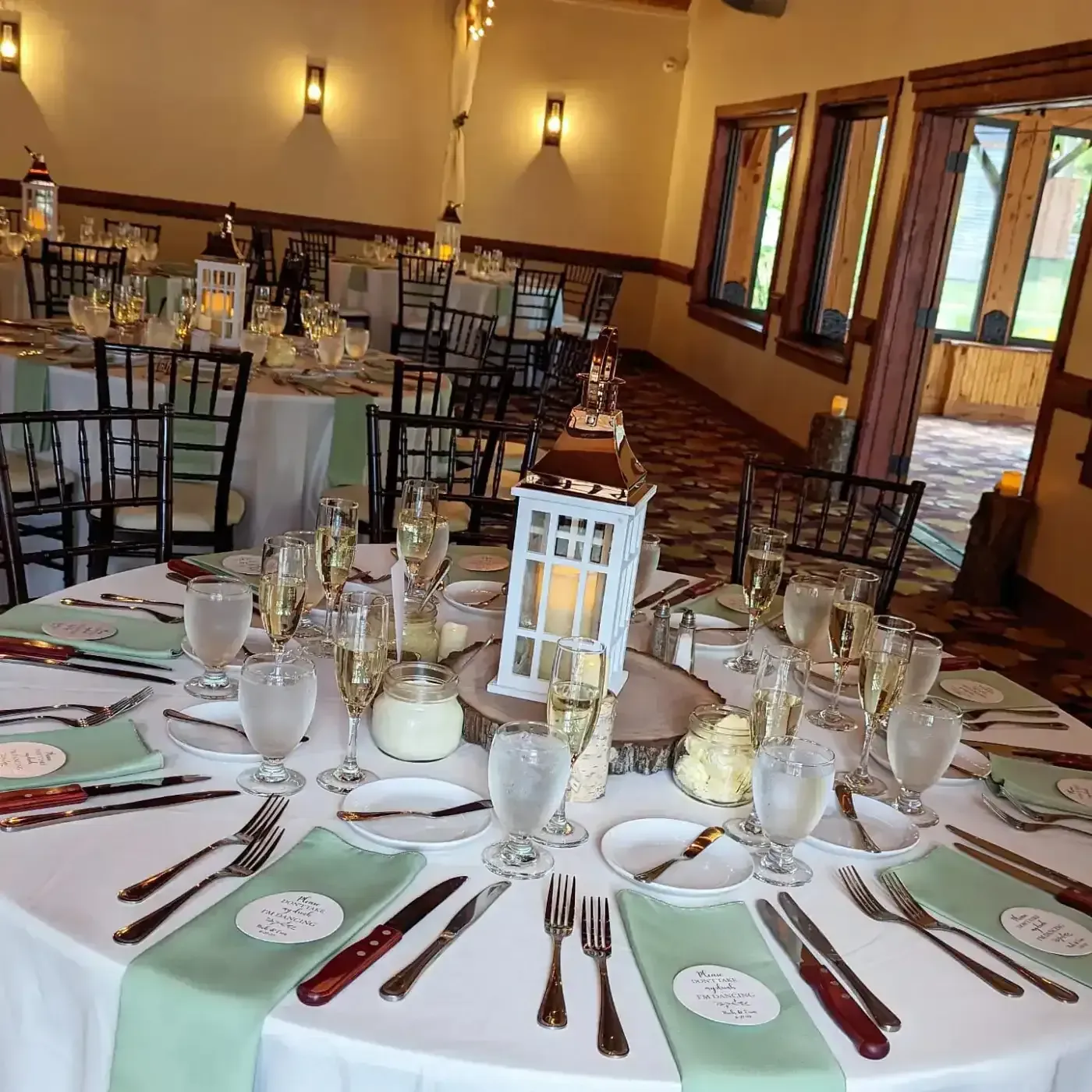 A large room with tables and chairs set up for a wedding reception