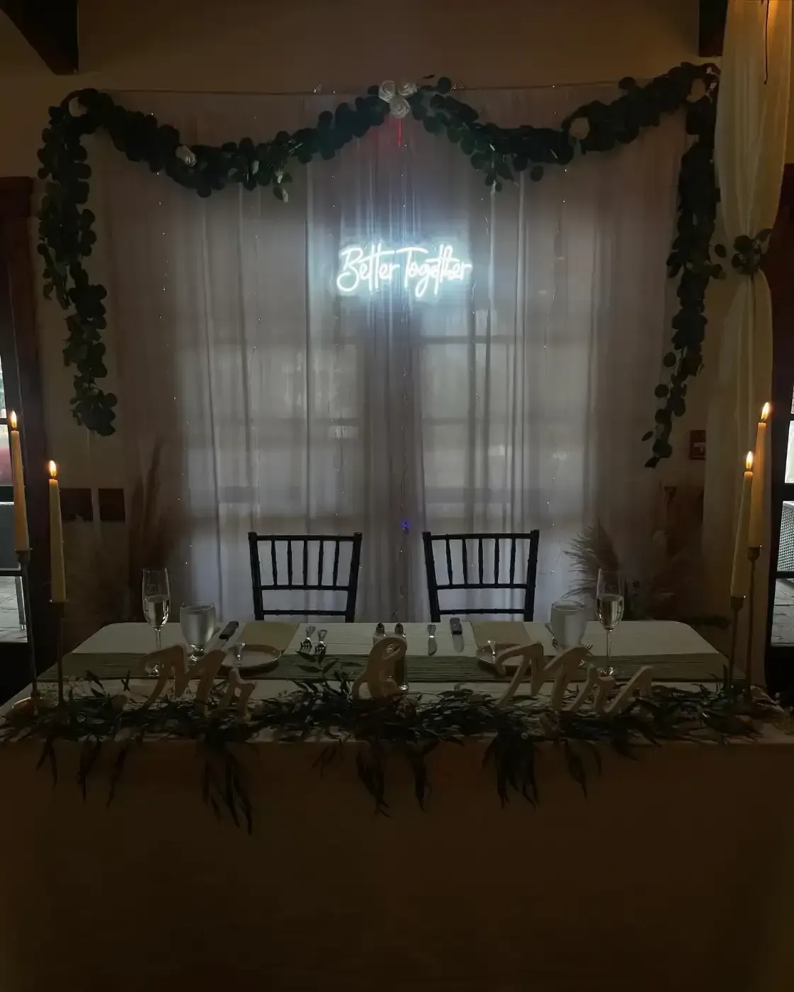 There is a neon sign on the wall above the head table.
