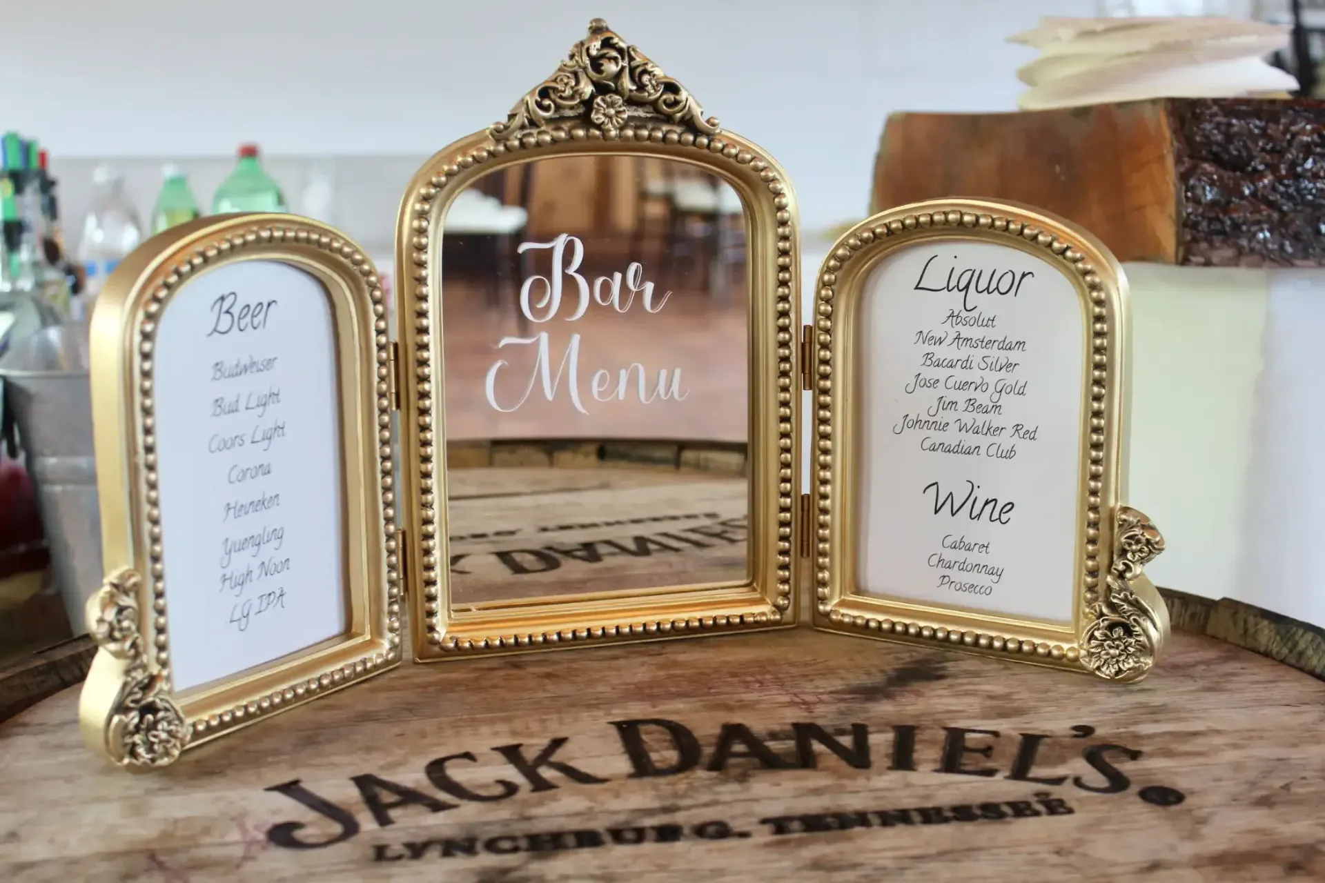 Three gold frames are sitting on top of a jack daniel 's barrel.