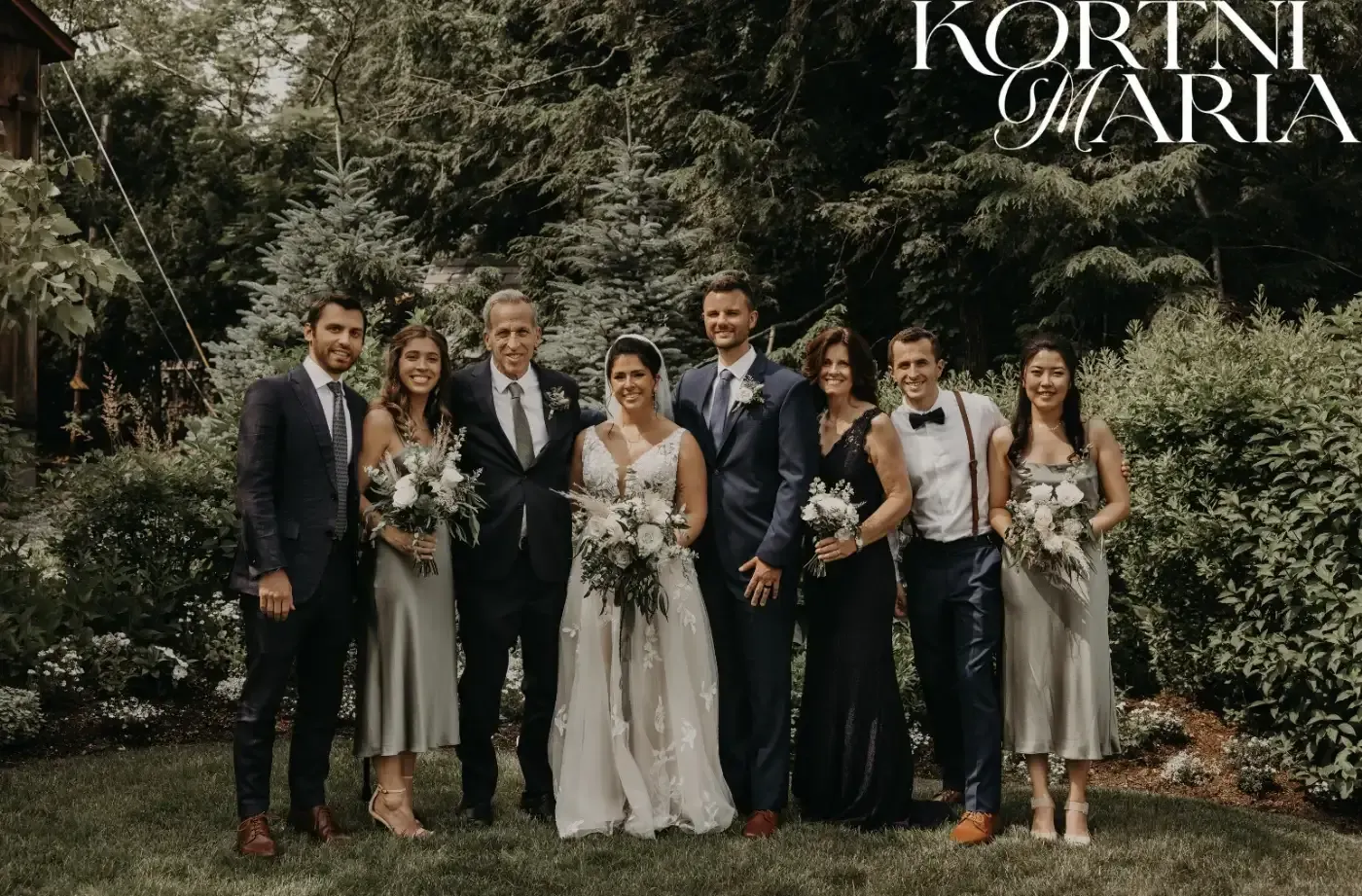 The bride and groom are posing for a picture with their wedding party.