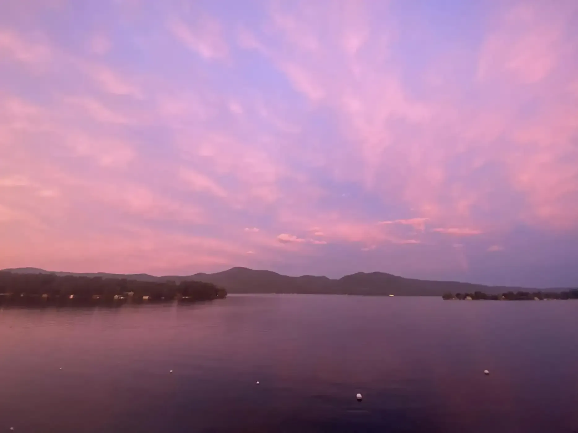 A sunset over a lake with mountains in the background