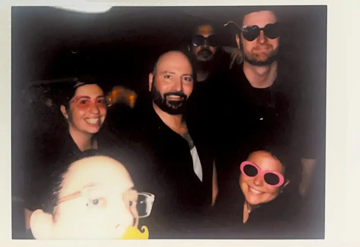 A group of people wearing sunglasses are posing for a picture.