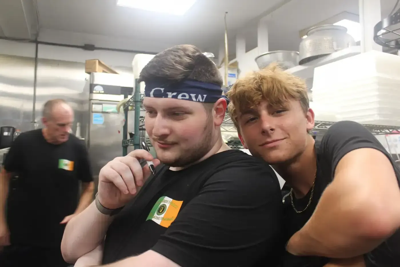 A man wearing a headband that says crow is standing next to another man