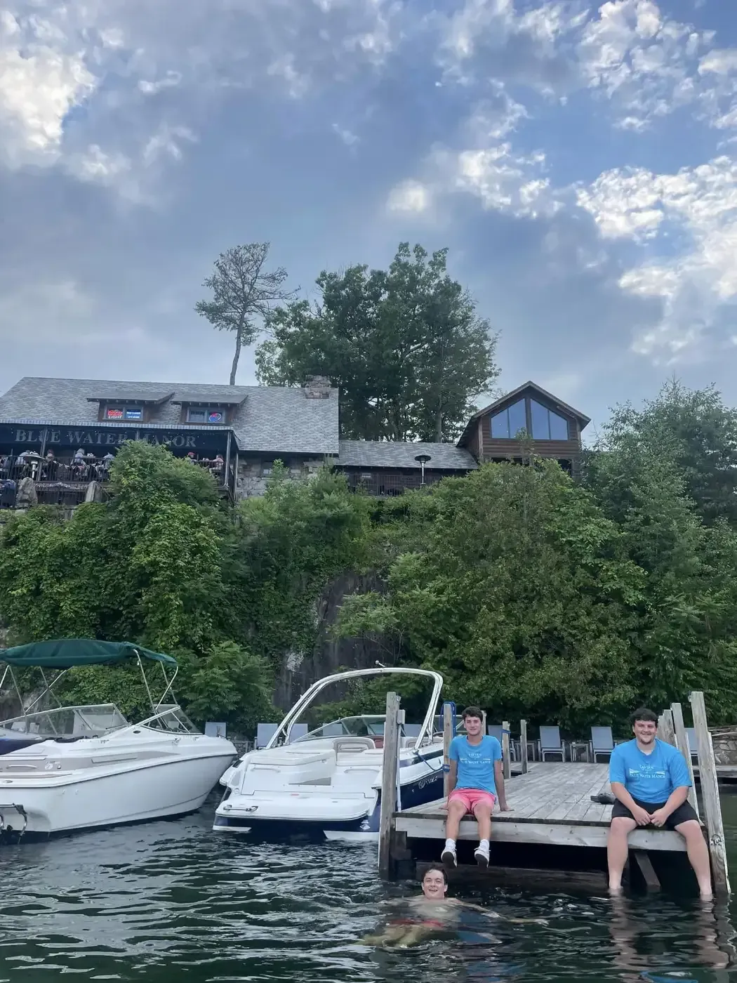 Two people are sitting on a dock next to a boat
