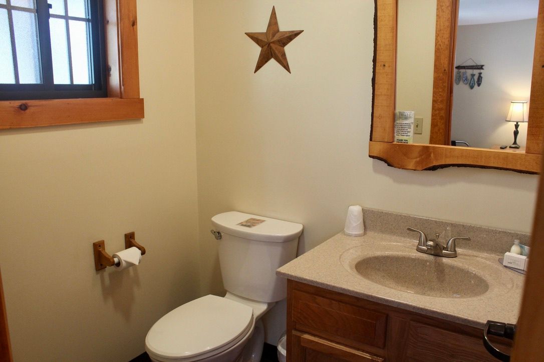 A bathroom with a toilet , sink and mirror