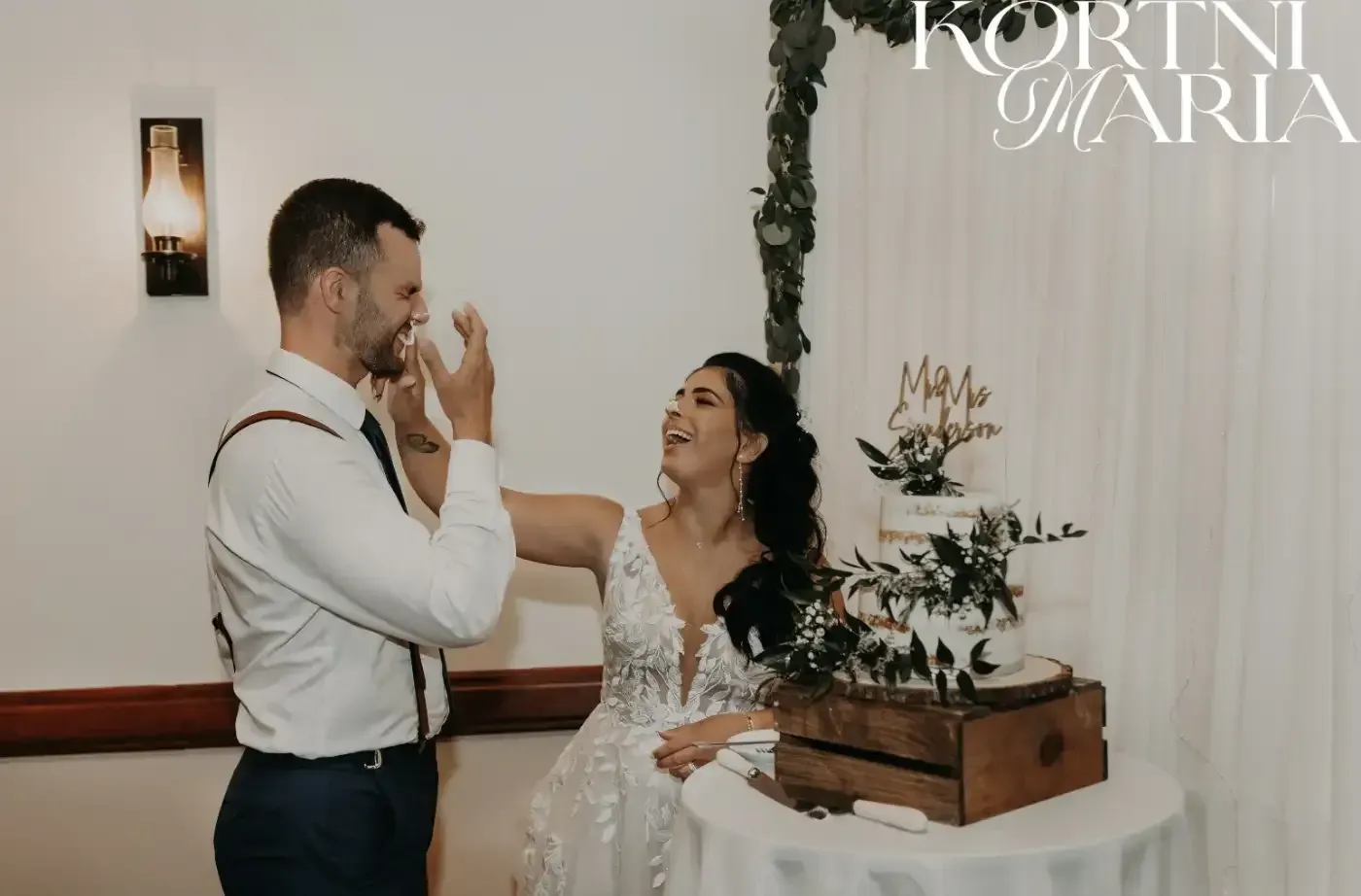 A bride and groom are cutting their wedding cake together.