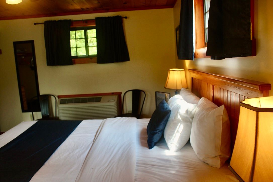 A hotel room with a king size bed and two lamps