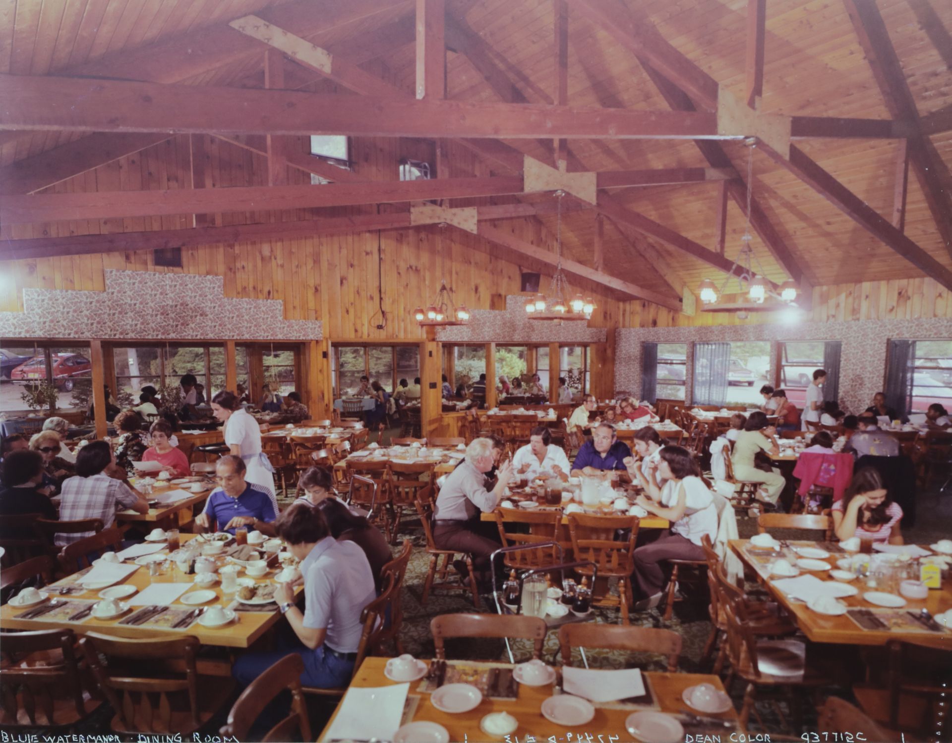 A group of people are sitting at tables in the old banquet hall