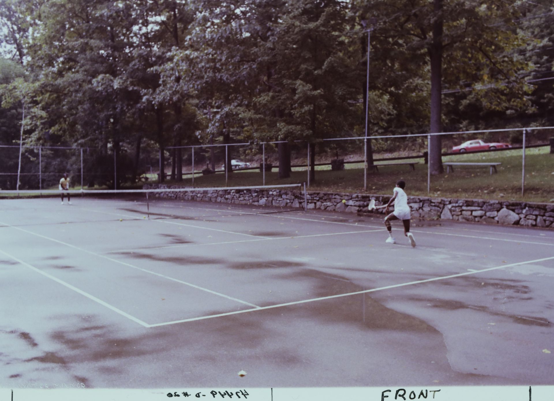 A person is playing tennis at the old Blue Water Manor court