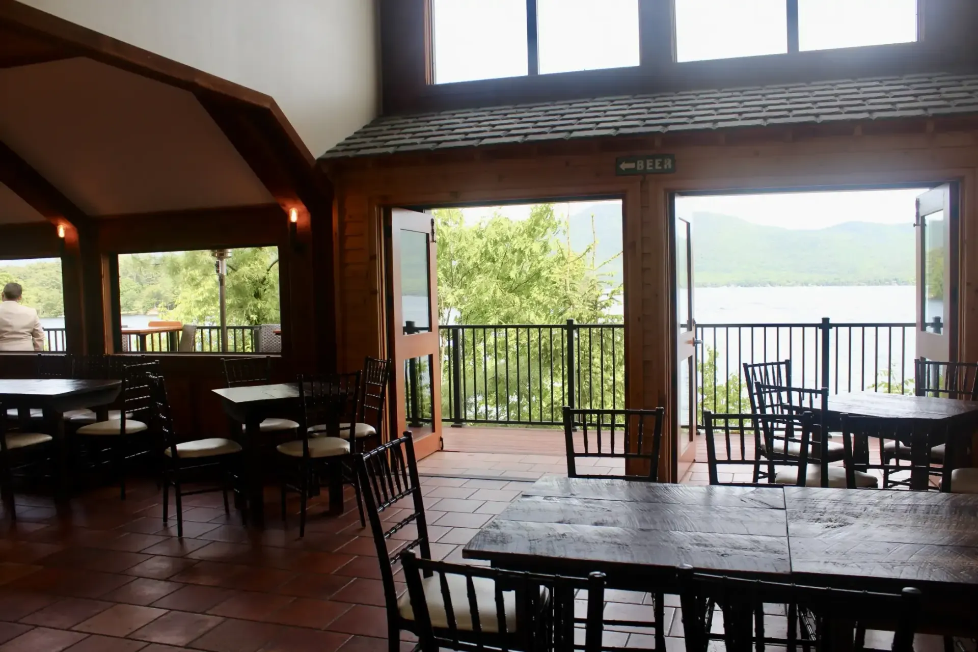 A restaurant with tables and chairs and a view of a lake