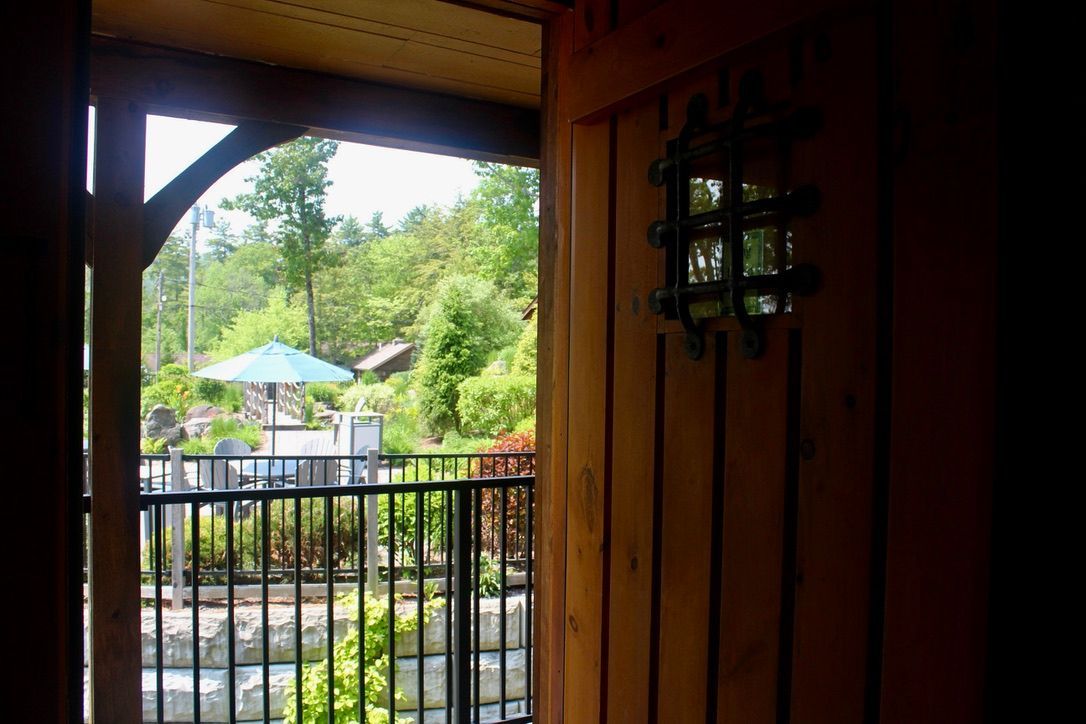 A wooden door with a metal railing and a view of a koi pond.