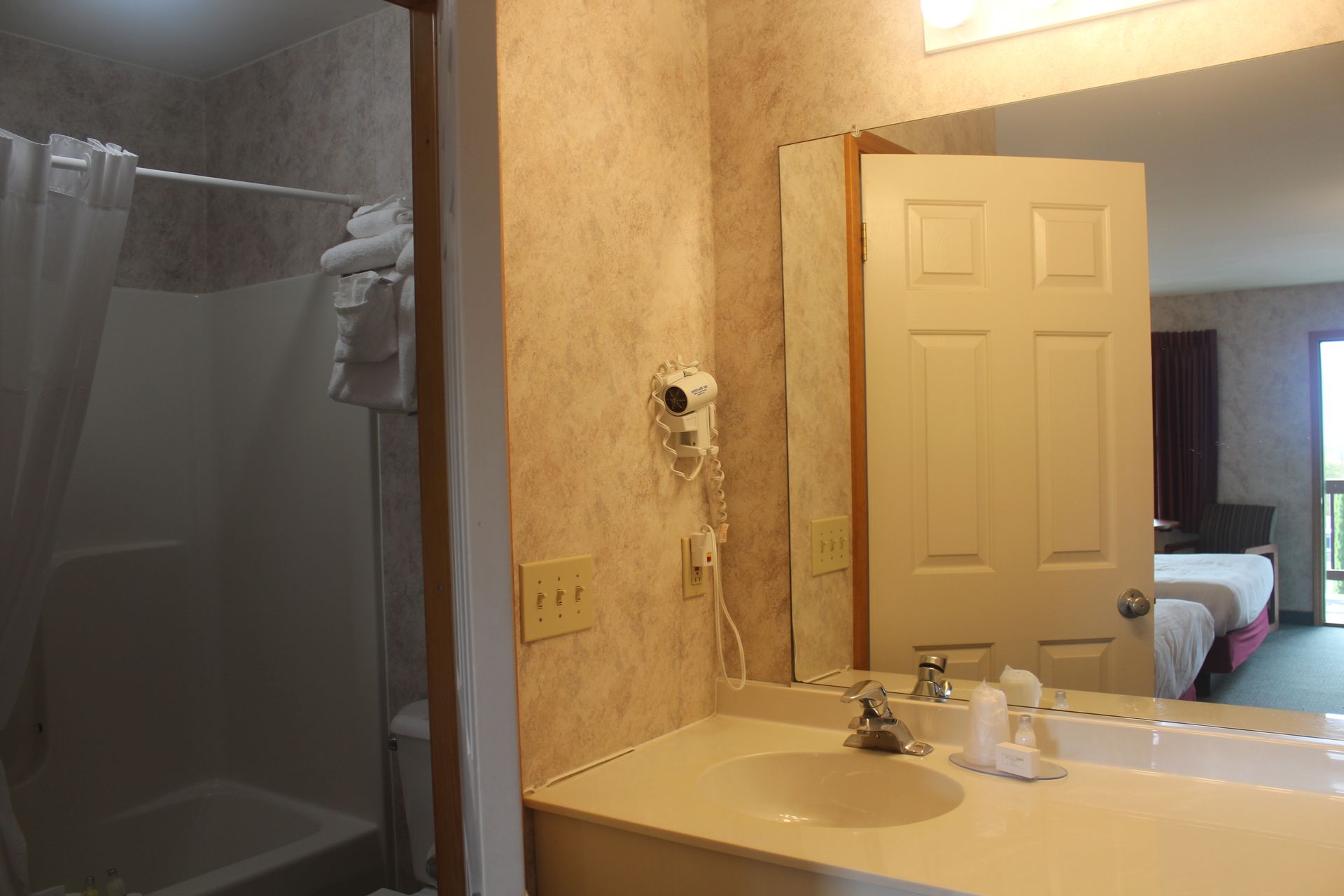 A bathroom in a hotel room with a sink and a mirror