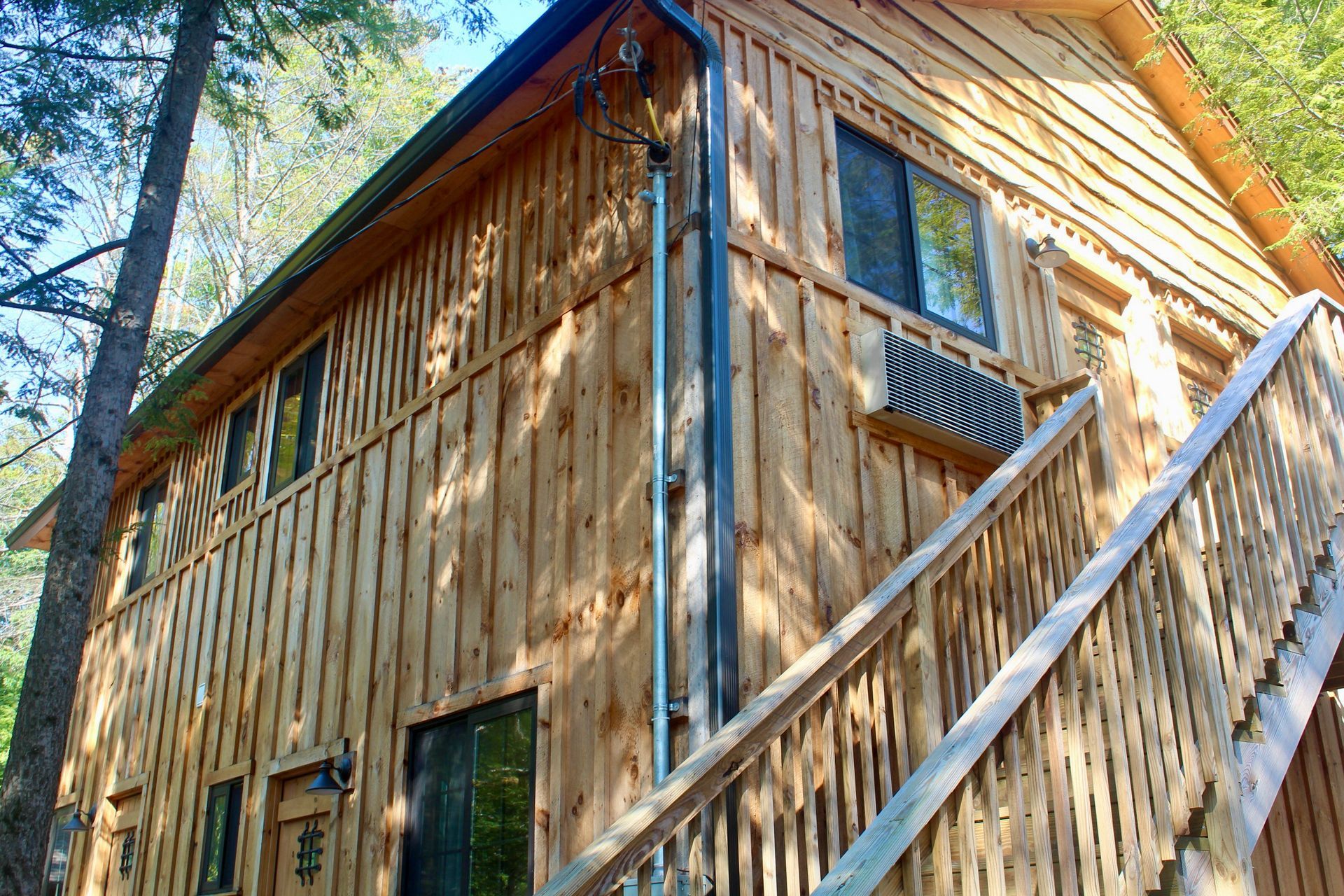 A wooden house with stairs leading up to the second floor