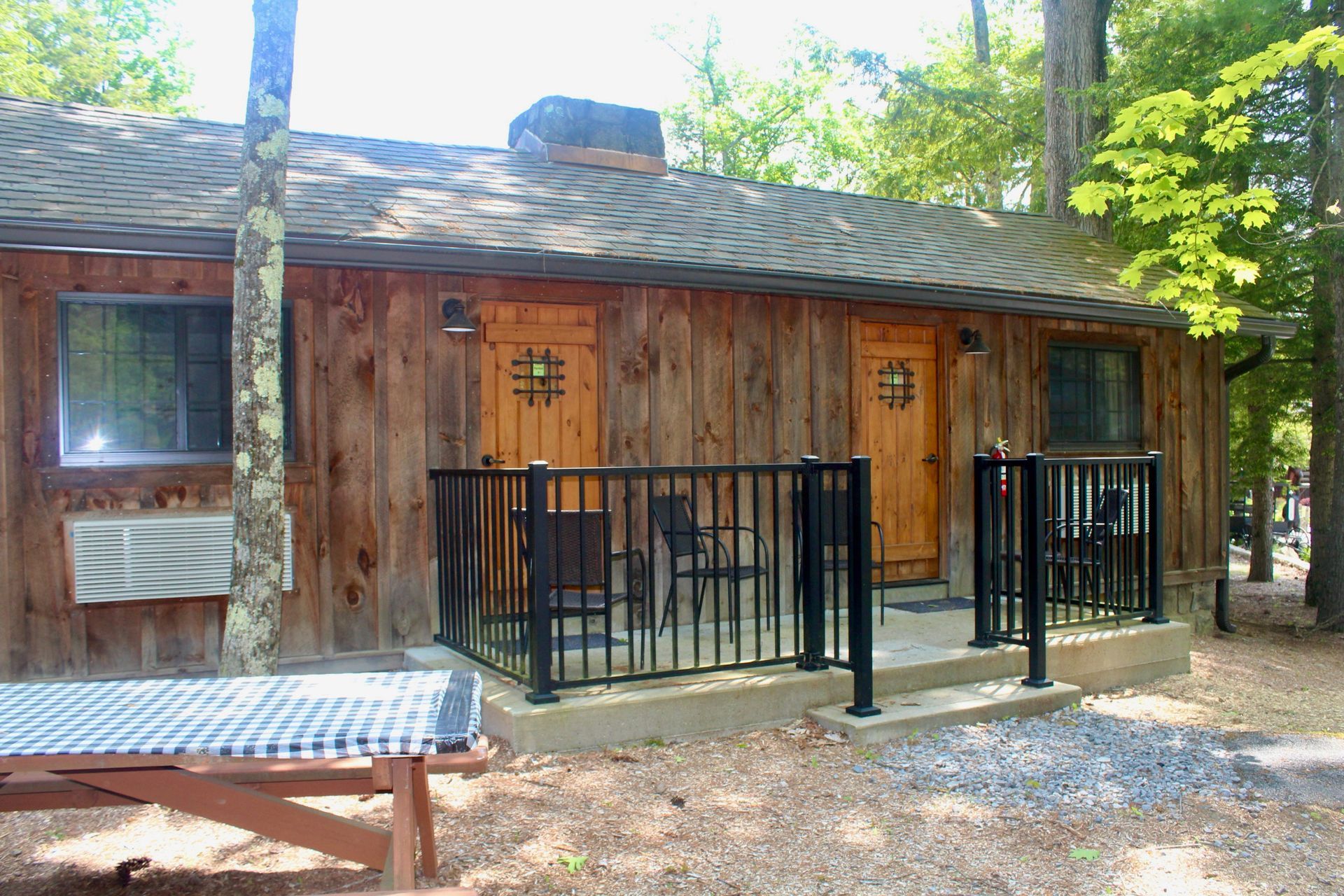 A wooden cabin with a picnic table in front of it