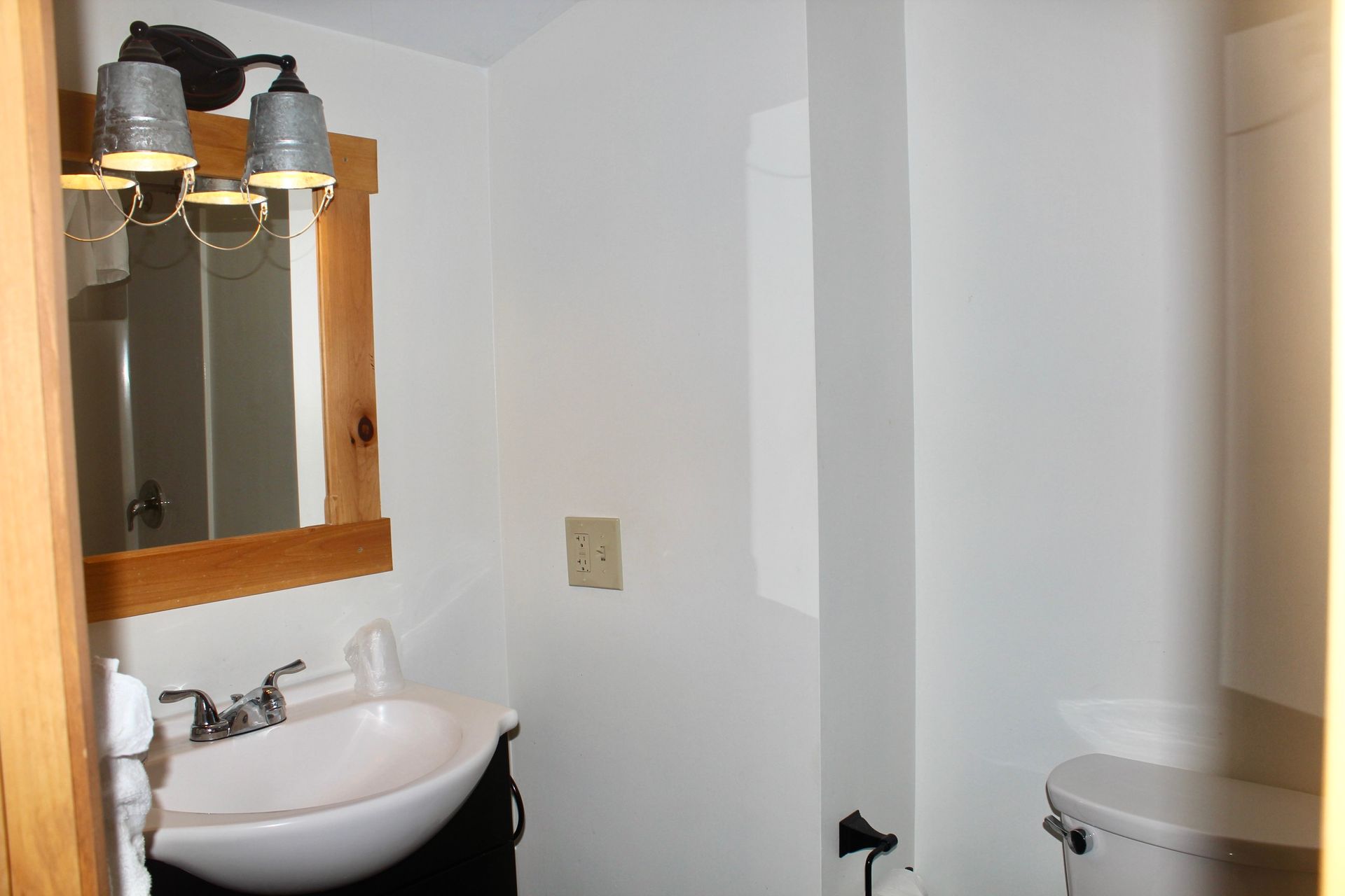A bathroom with a sink a toilet and a mirror