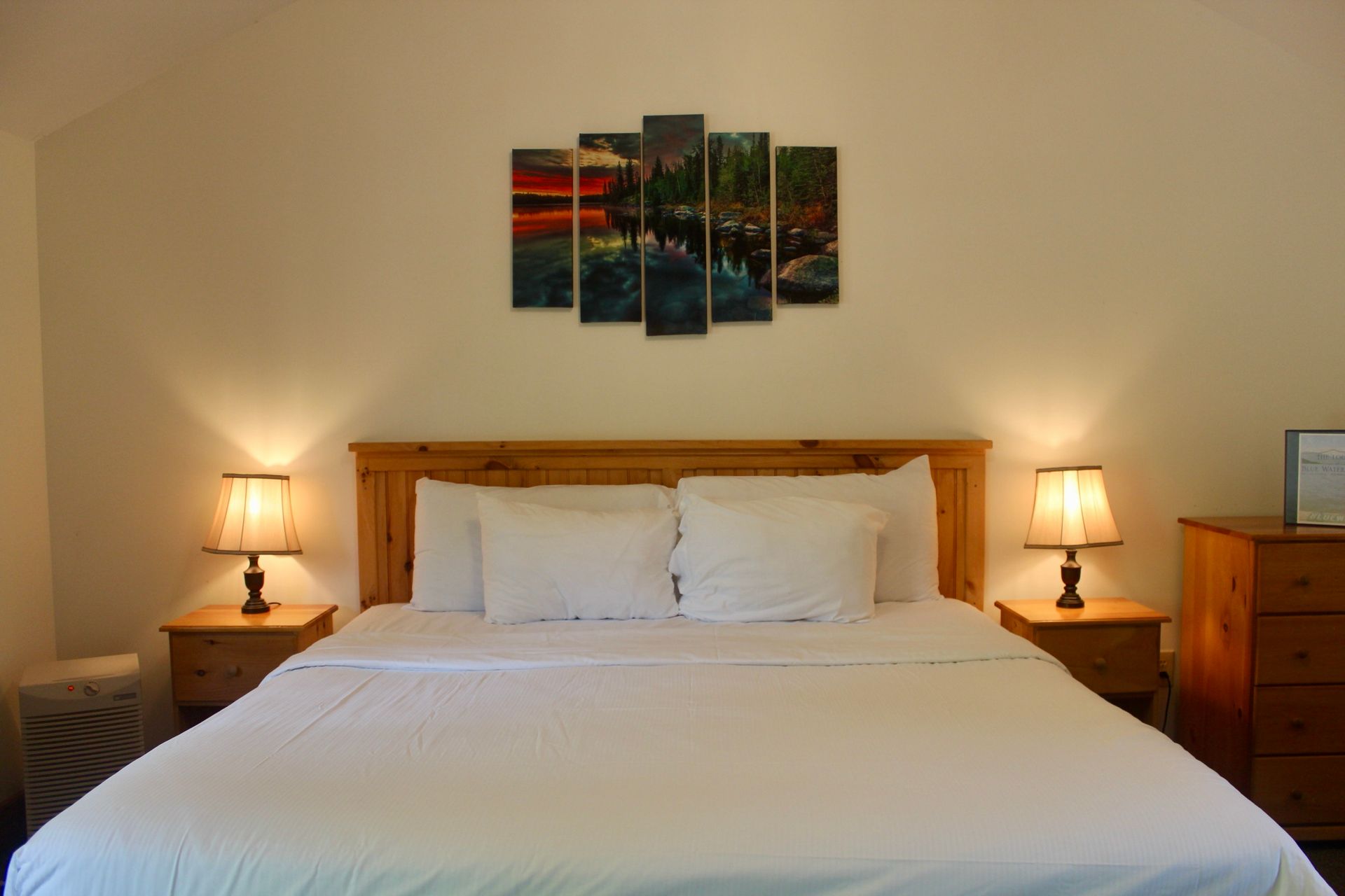 A bedroom with a king size bed and two lamps