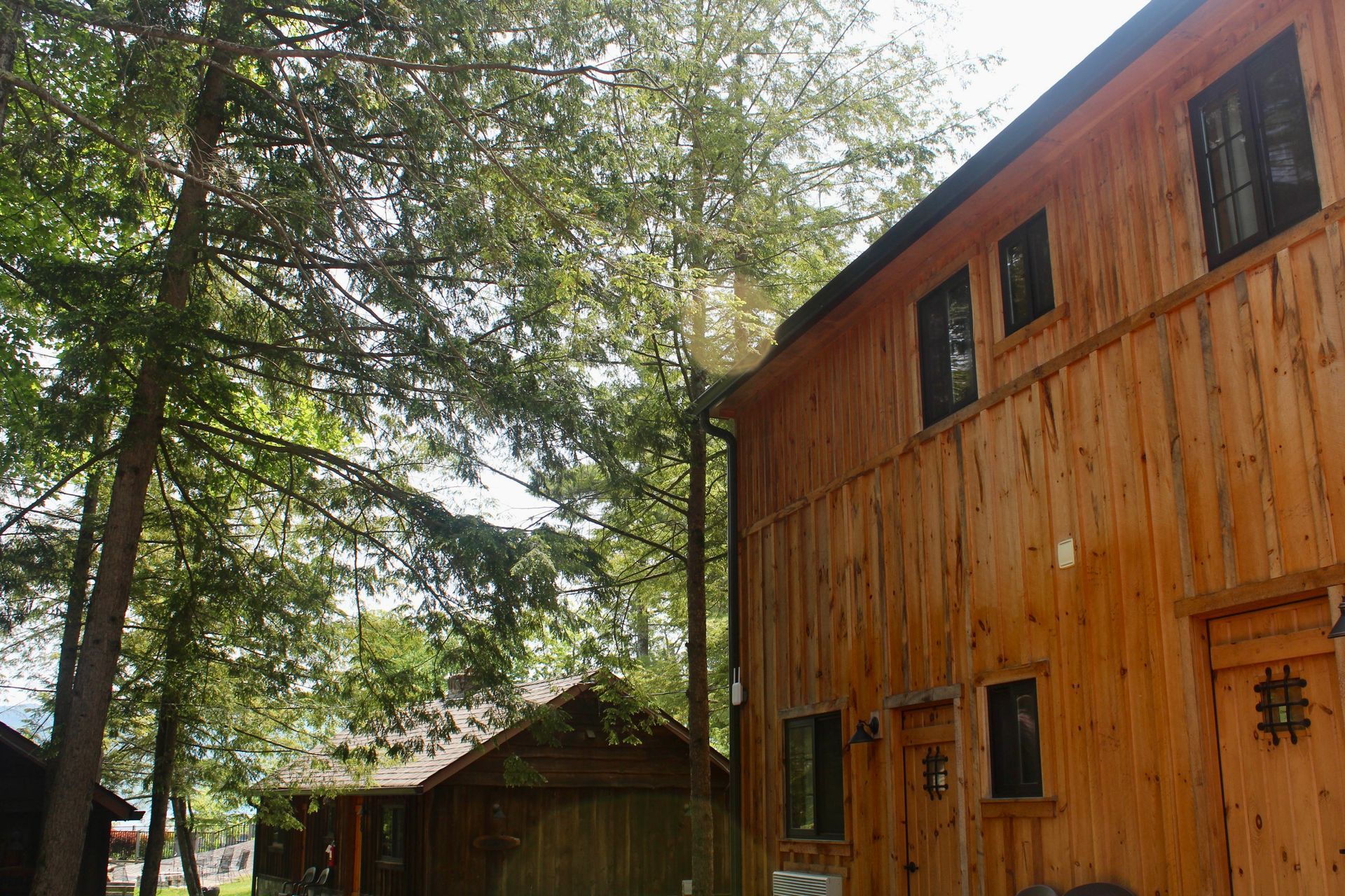 A wooden building with a lot of windows and trees in the background