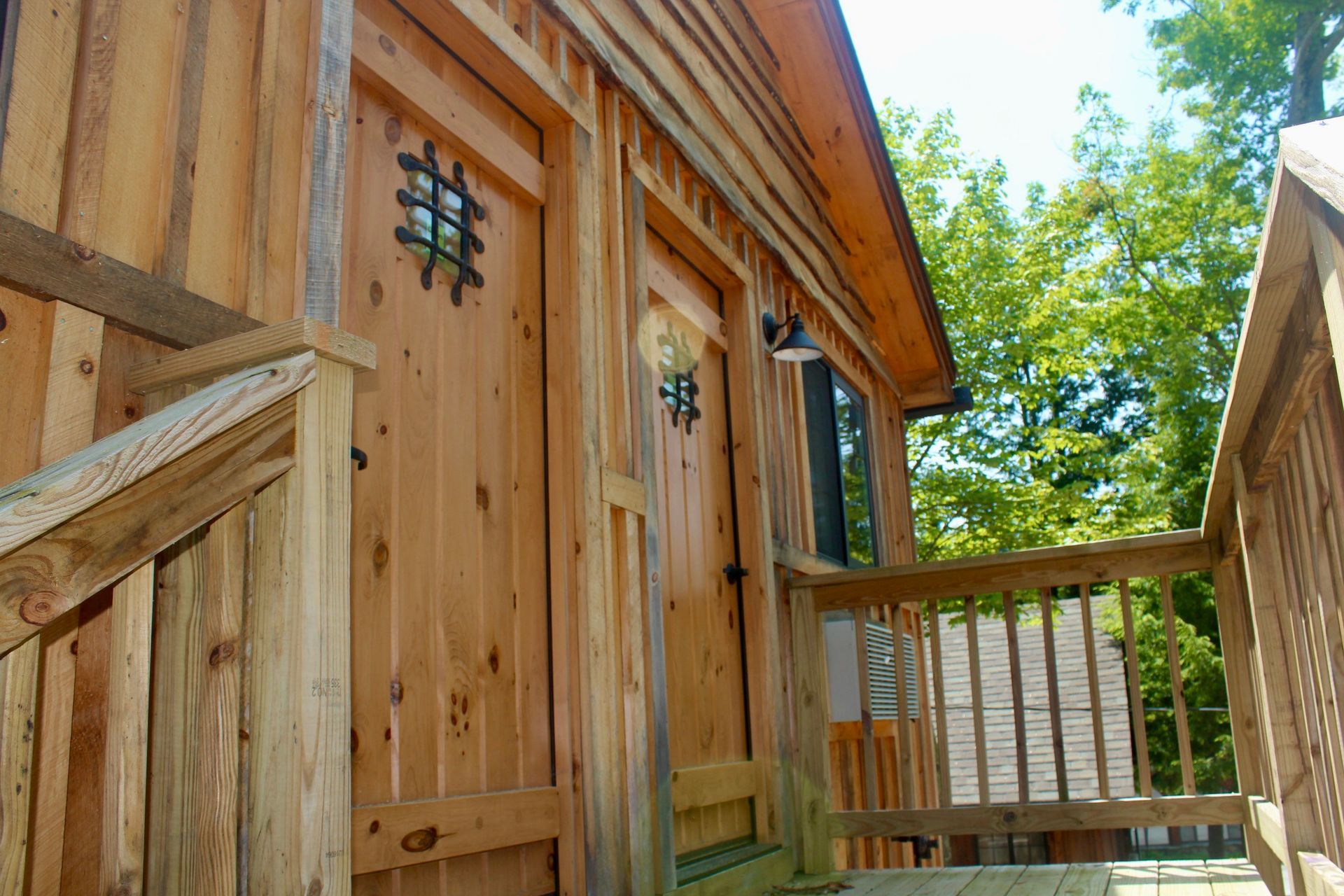 A wooden building with a deck and stairs leading up to it.