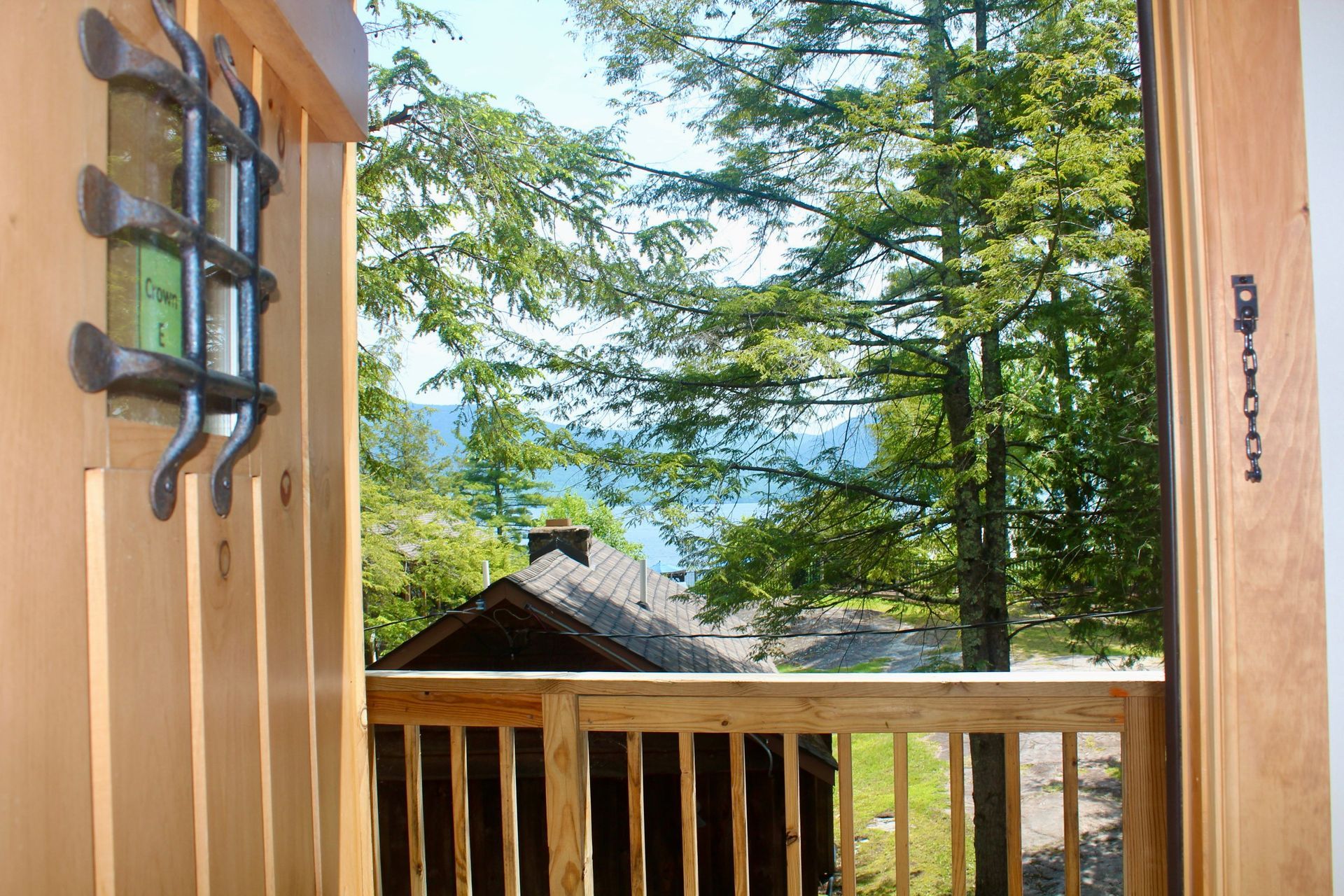 A balcony with a view of a house and trees