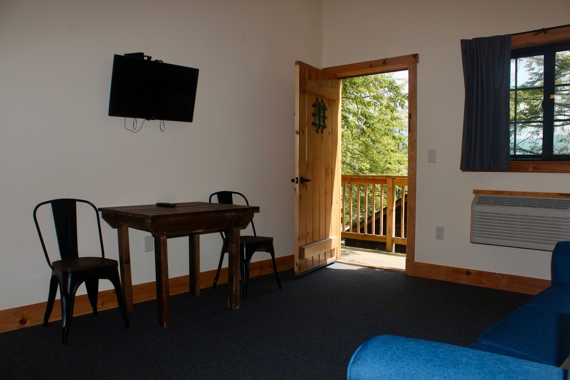 A living room with a table and chairs and a flat screen tv.