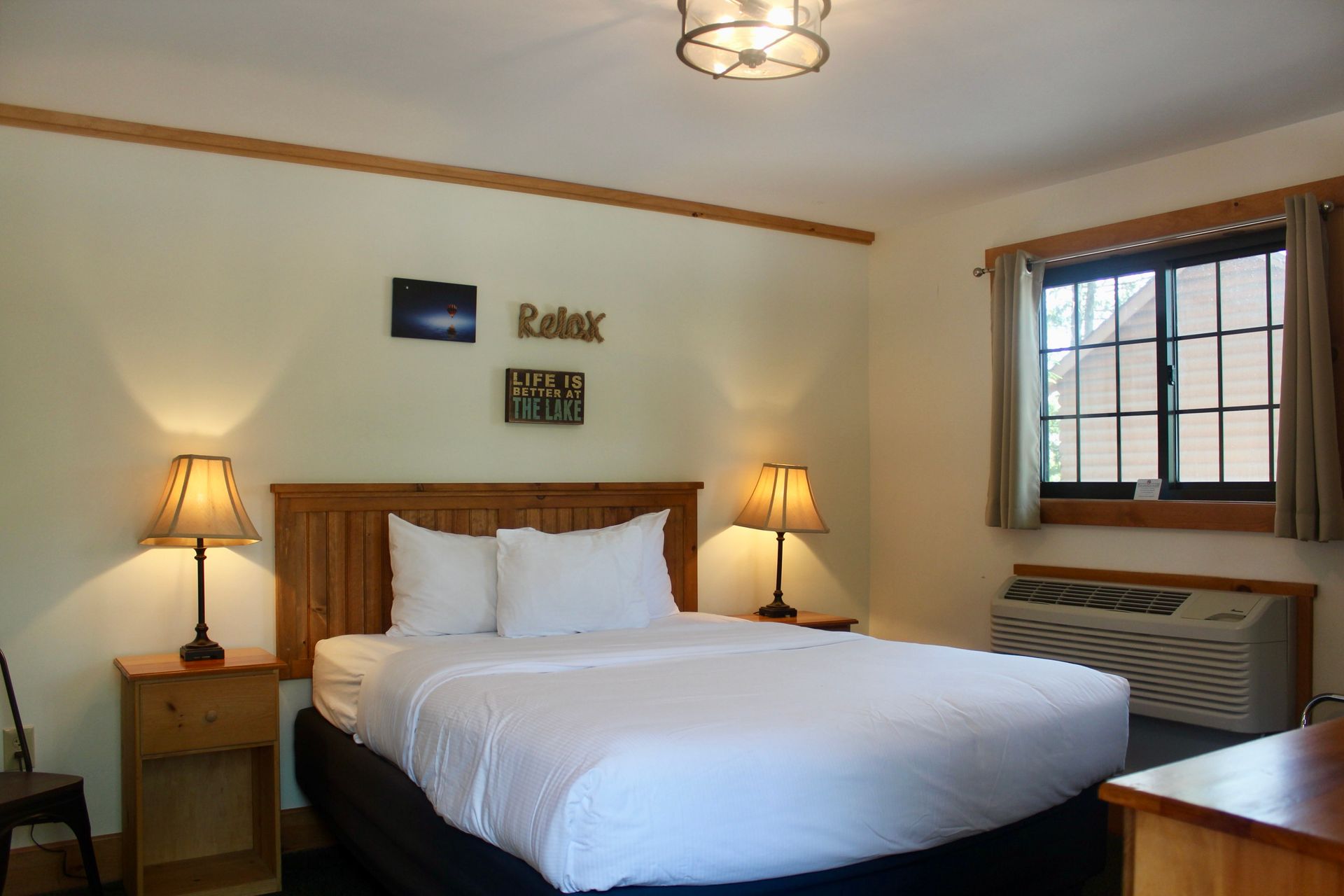 A hotel room with a king size bed and a sign on the wall that says relax