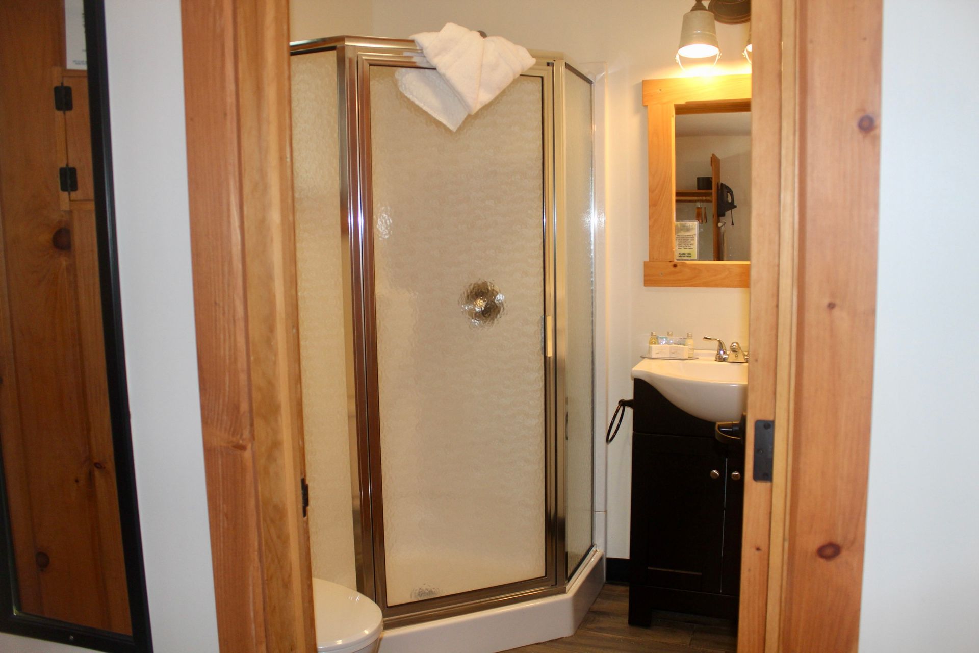 A bathroom with a walk in shower and a sink