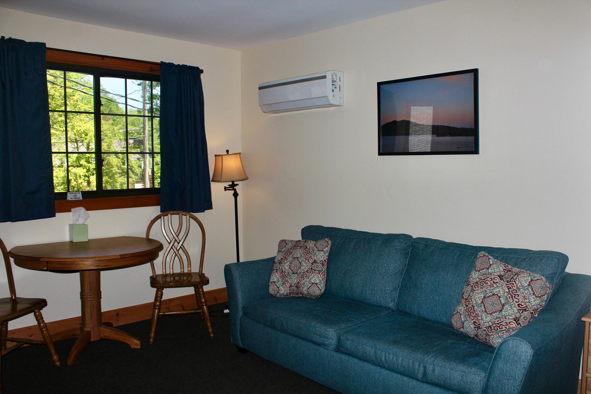 A living room with a blue couch and a table