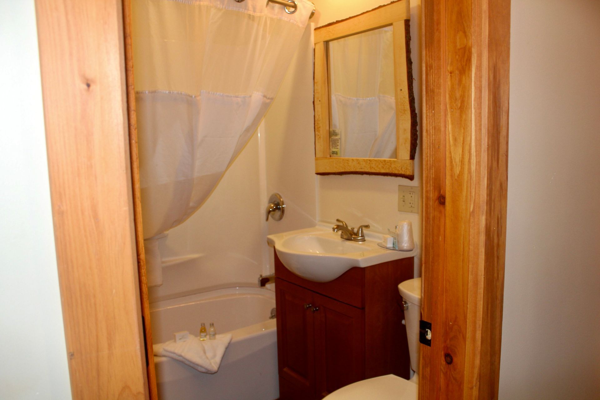A bathroom with a sink , toilet , tub and mirror.