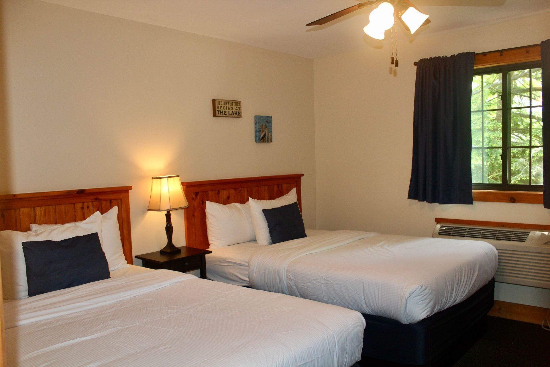 A hotel room with two beds and a window