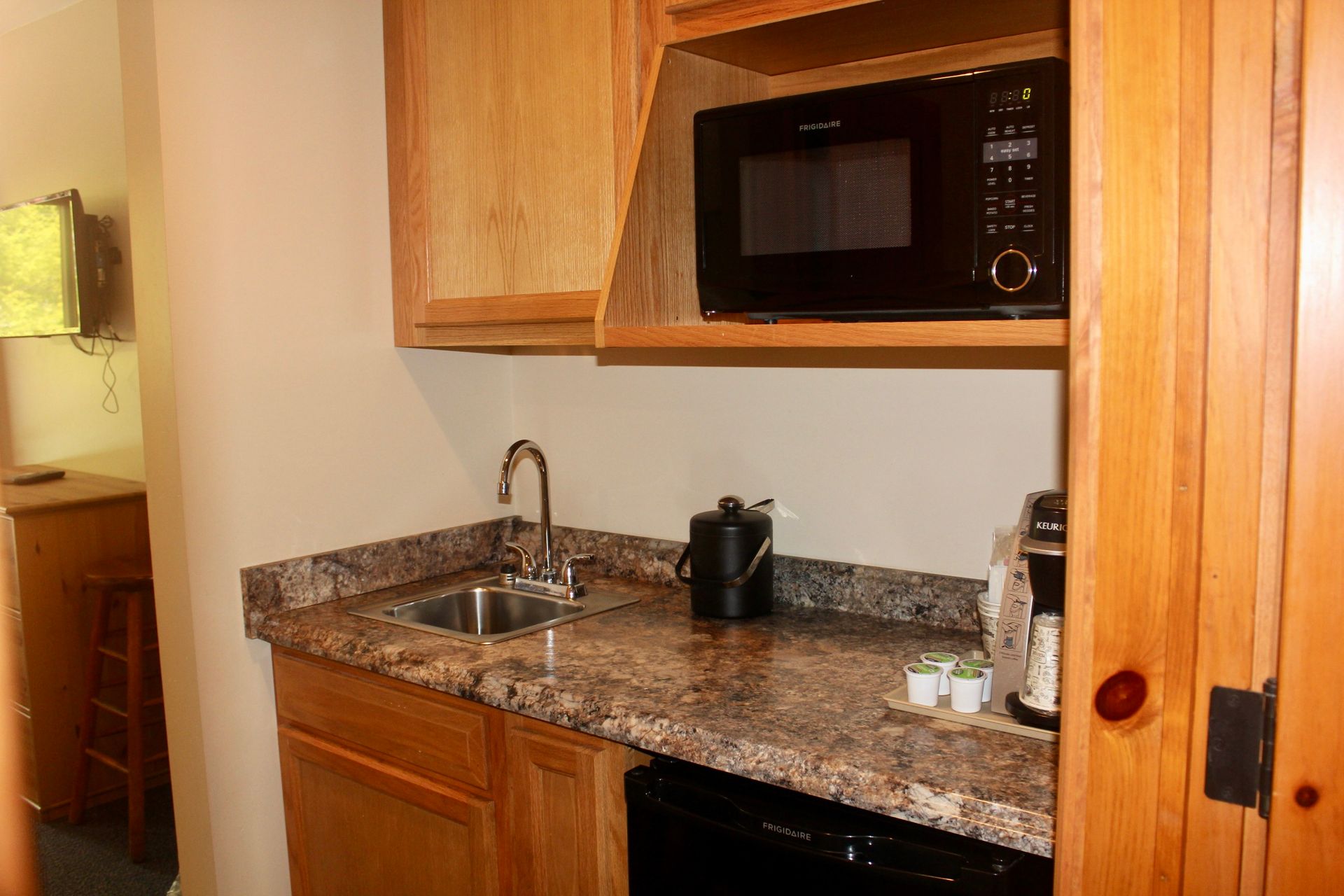 A small kitchen with a sink , microwave , and dishwasher.
