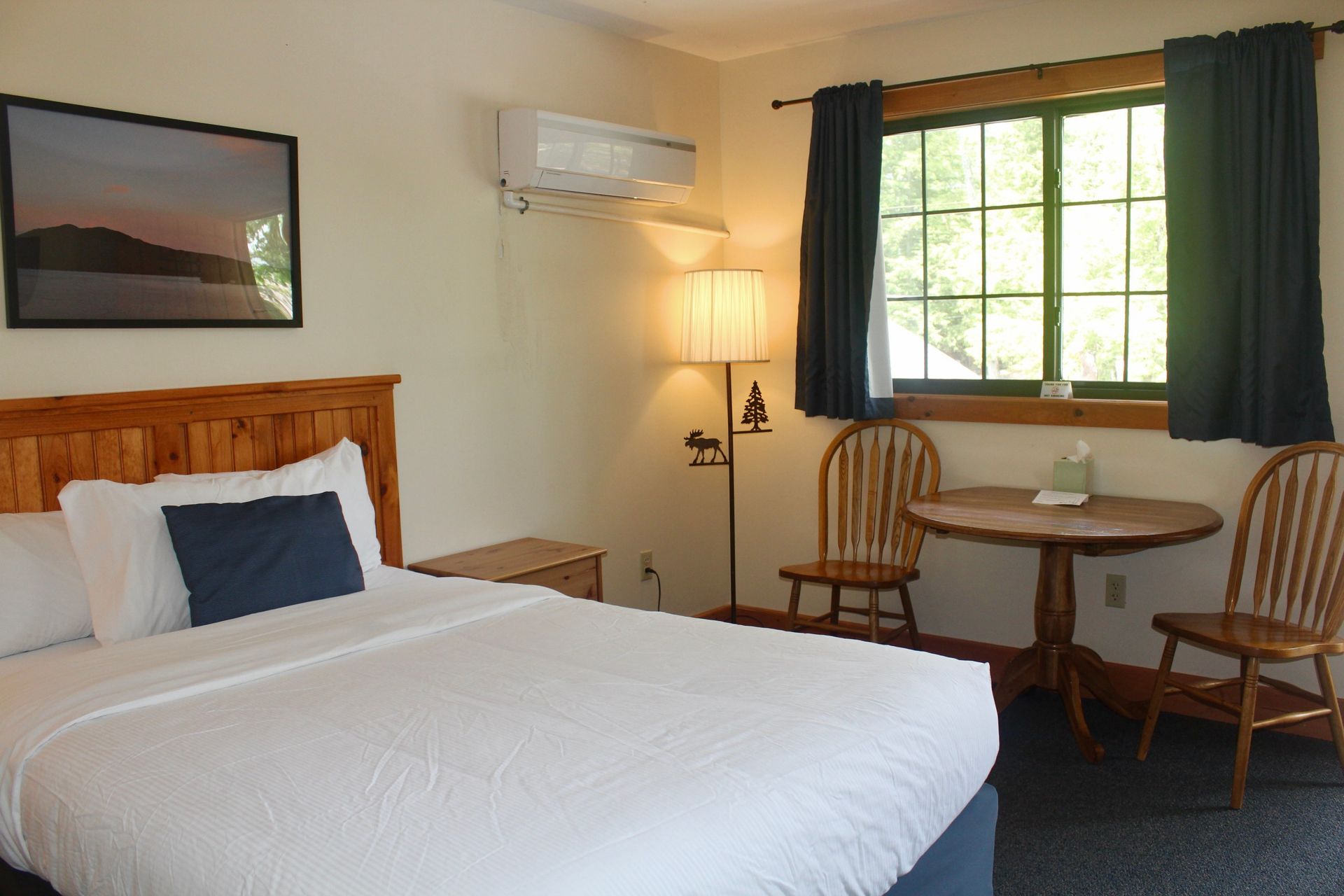 A hotel room with a bed , table and chairs
