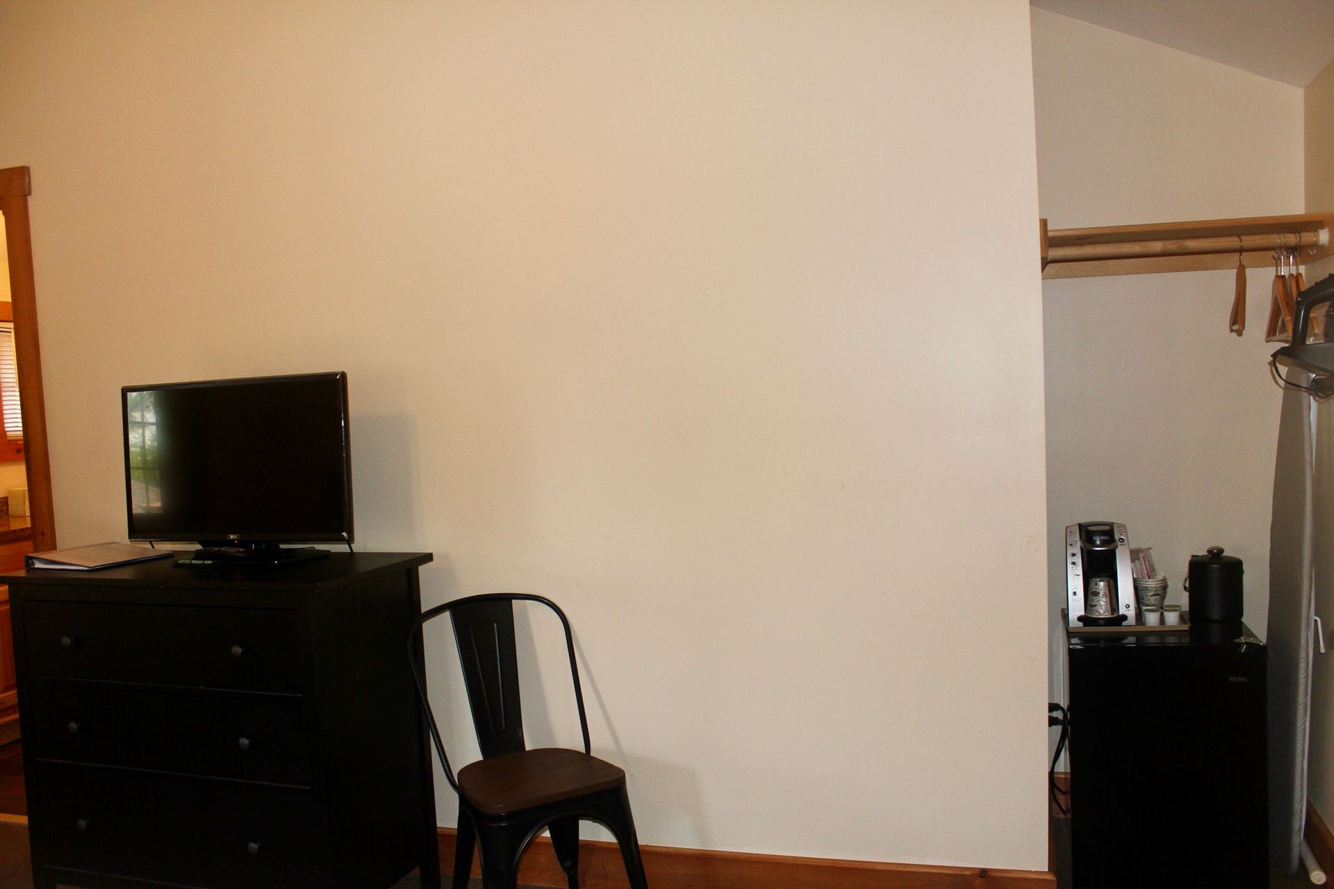A room with a chair , dresser , and television.