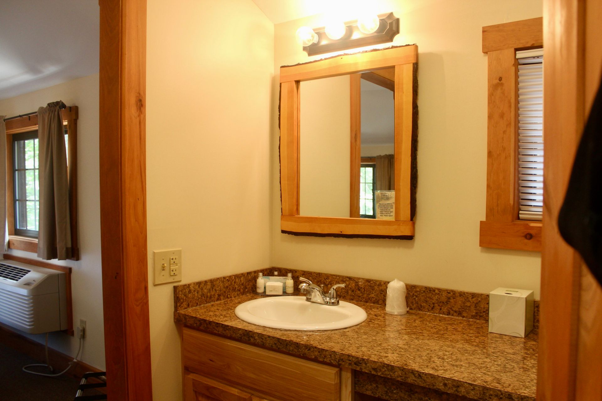 A bathroom with a sink a mirror and a window