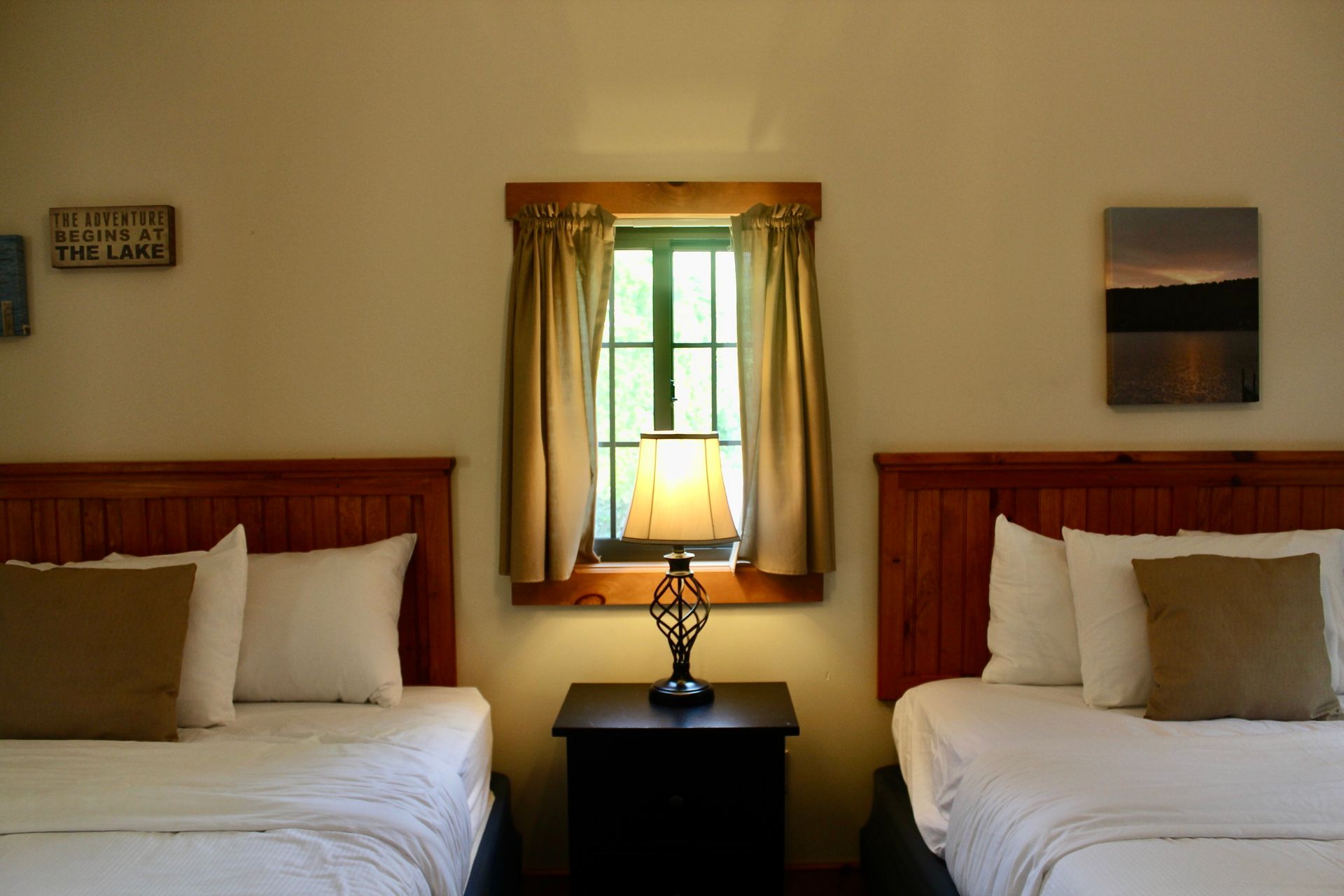 A hotel room with two beds and a lamp